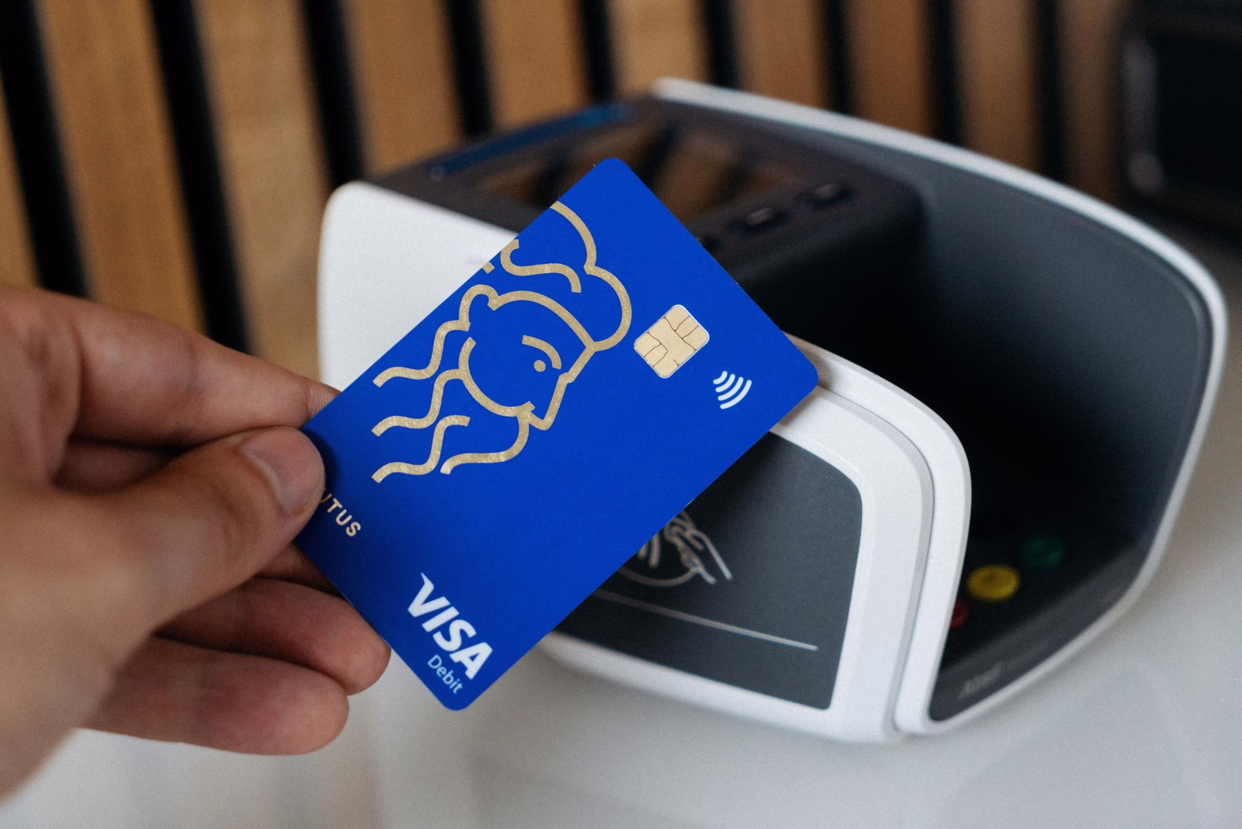 A Visa card being held to next to a payment terminal. (CardMapr.nl/Unsplash)