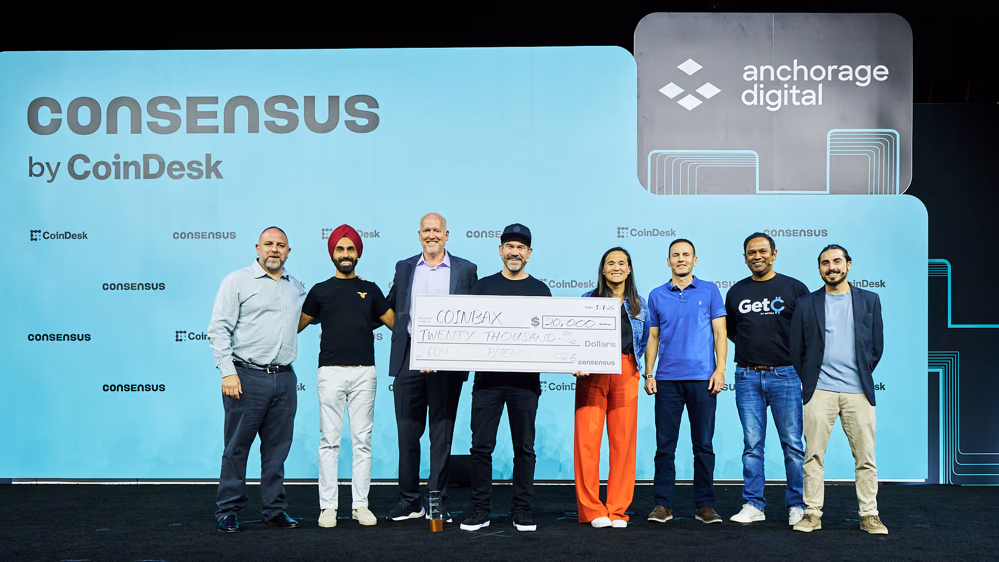 Coinbax founder, Peter Glyman (center), accepting his prize on the Consensus Miami Mainstage.