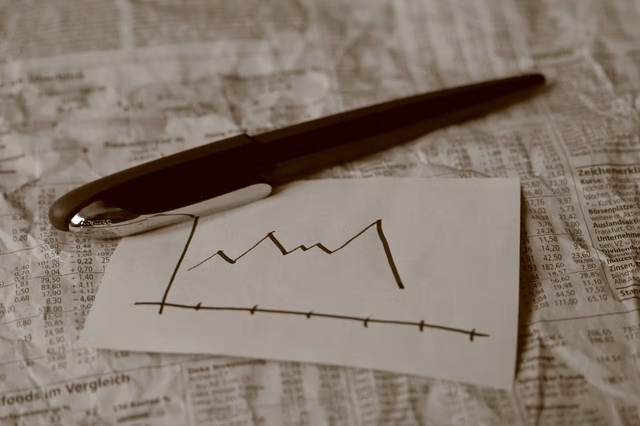 pen rests on paper showing sketched graph going lower. 