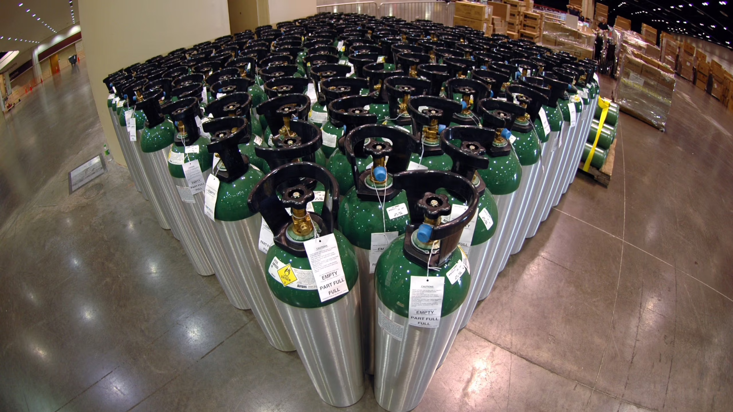Oxygen cylinders stand in a warehouse.